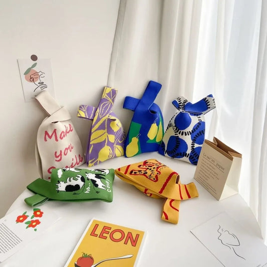 Colourful knitted bags on a white surface