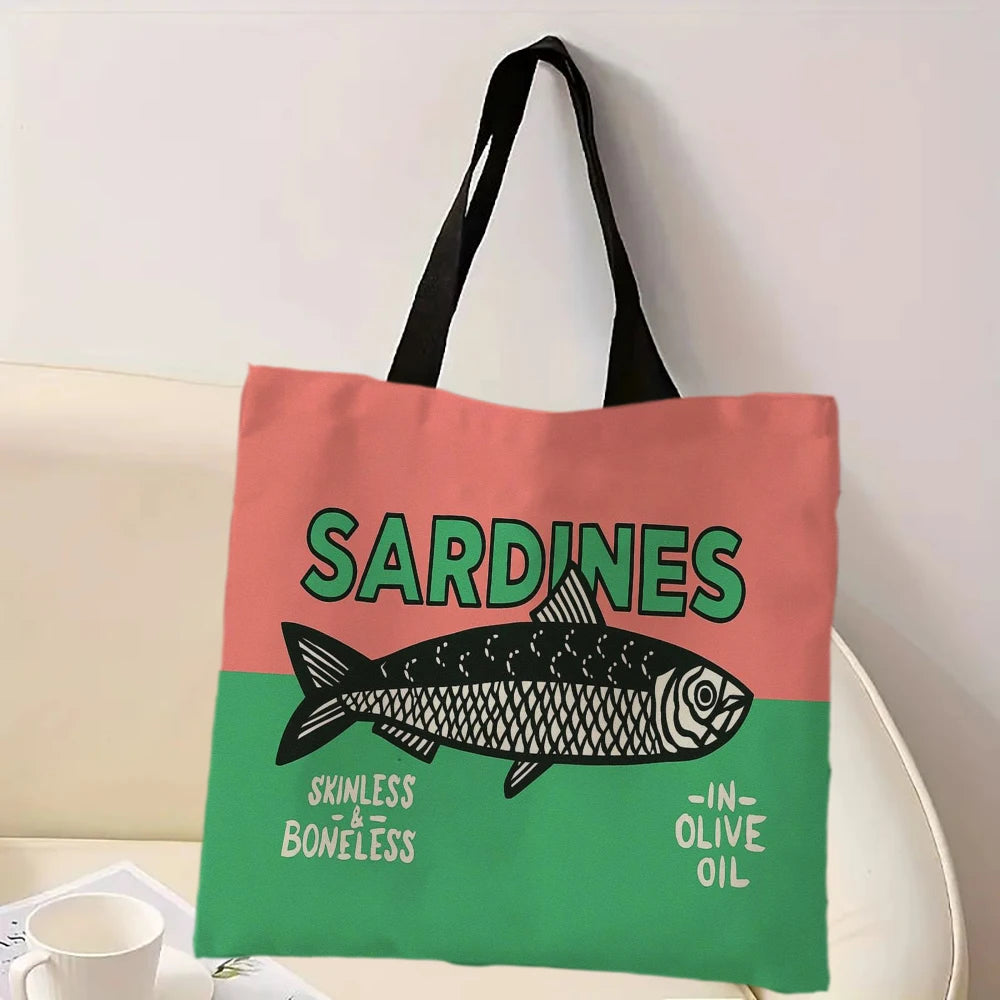 Tote bag, half pink and half green, with sardine design and text on a white surface