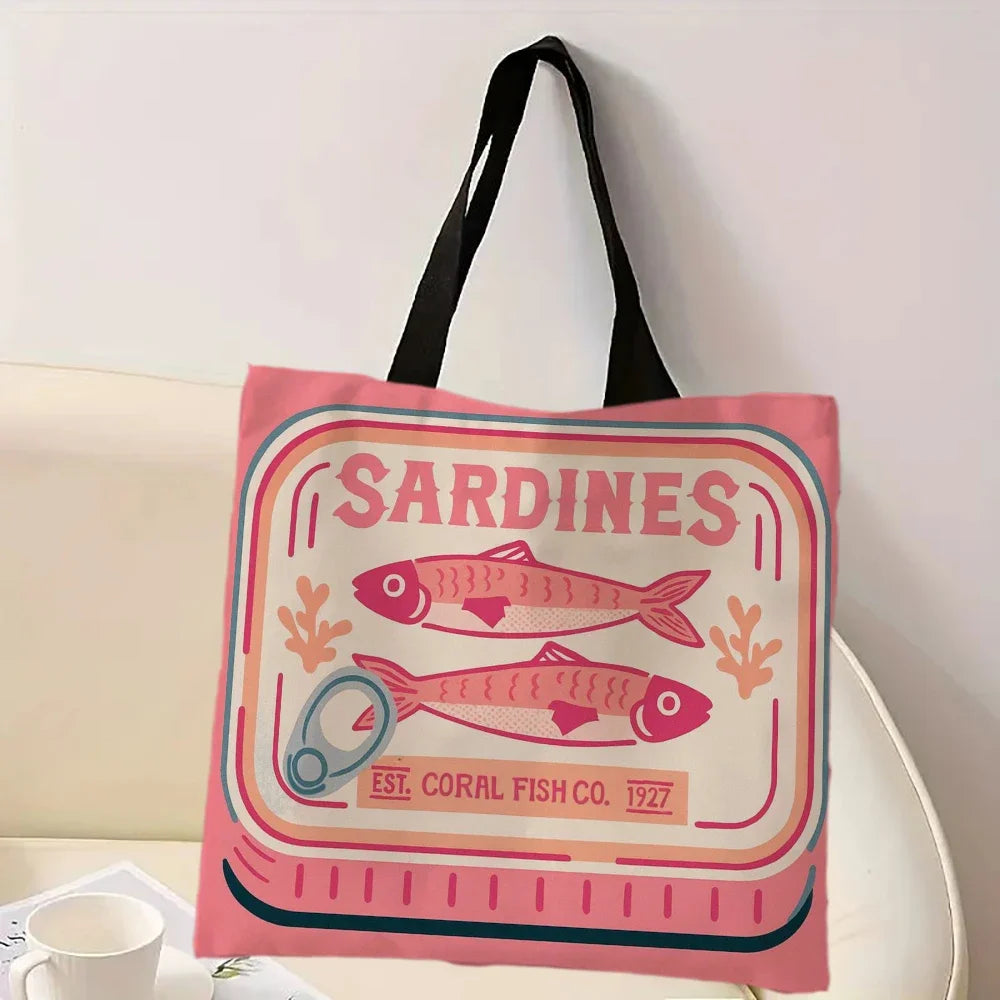 Tote bag in pink, with sardine design and 'Sardines' text on a white surface